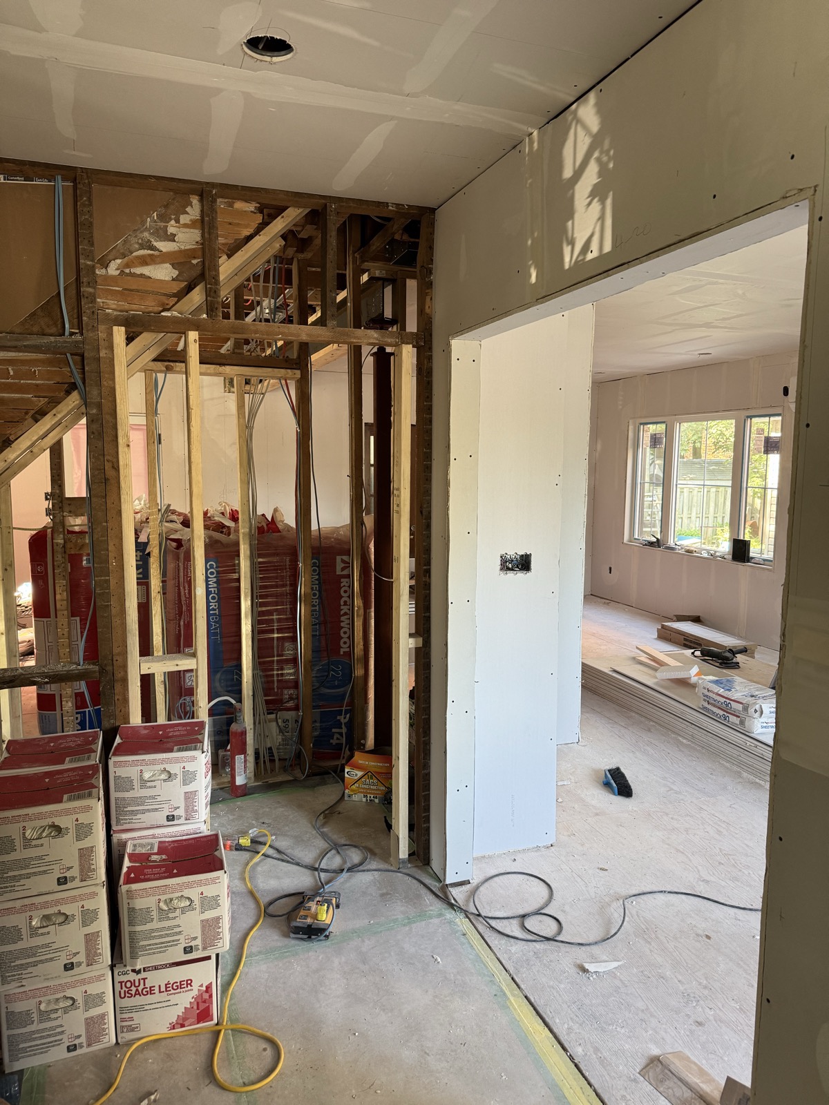 Hallway and doorway boarded with drywall, compound boxes stacked nearby